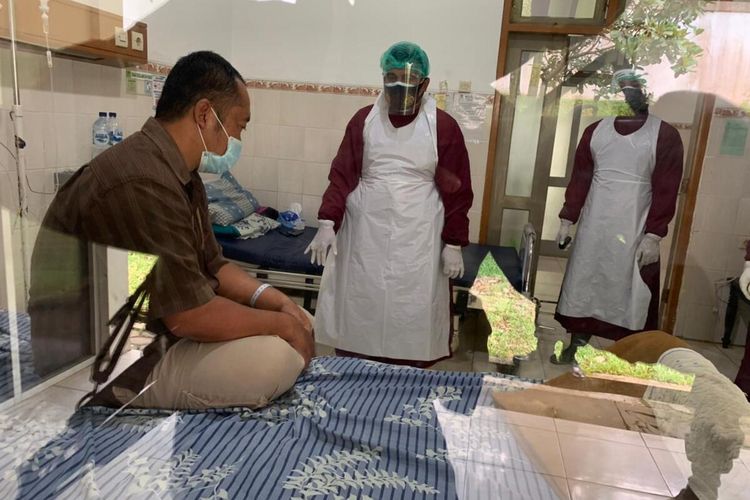 TENANGKAN--Mengenakan alat pelindung diri, anggota Polres Wonogiri menenangkan pasien positif covid-19 yang mengamuk minta pulang di Rumah Sakit Medika Mulya Wonogiri, Selasa (9/3/2021).