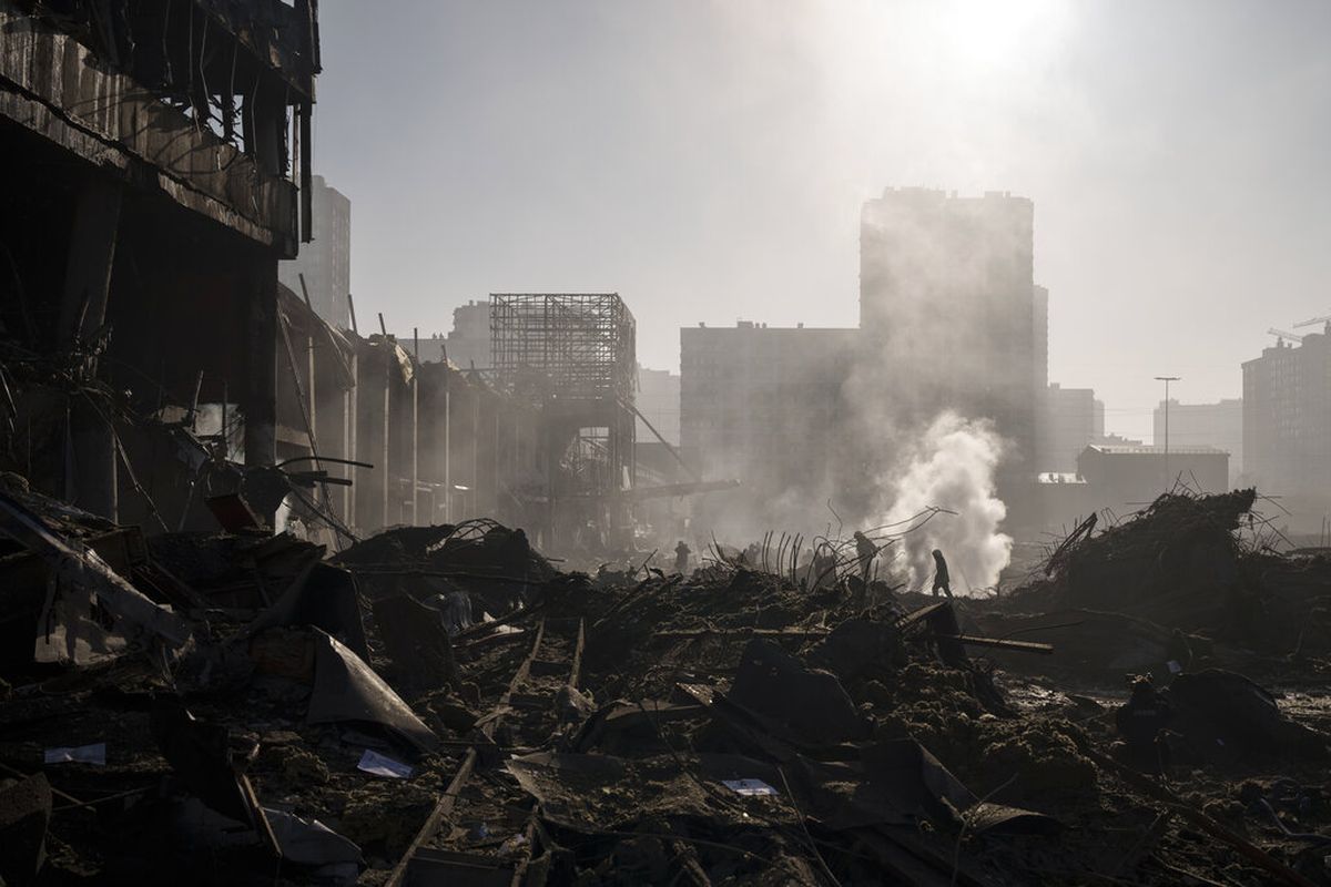 Petugas pemadam kebakaran memadamkan api di dekat pusat perbelanjaan setelah penembakan, di Kyiv, Ukraina, Senin, 21 Maret 2022.