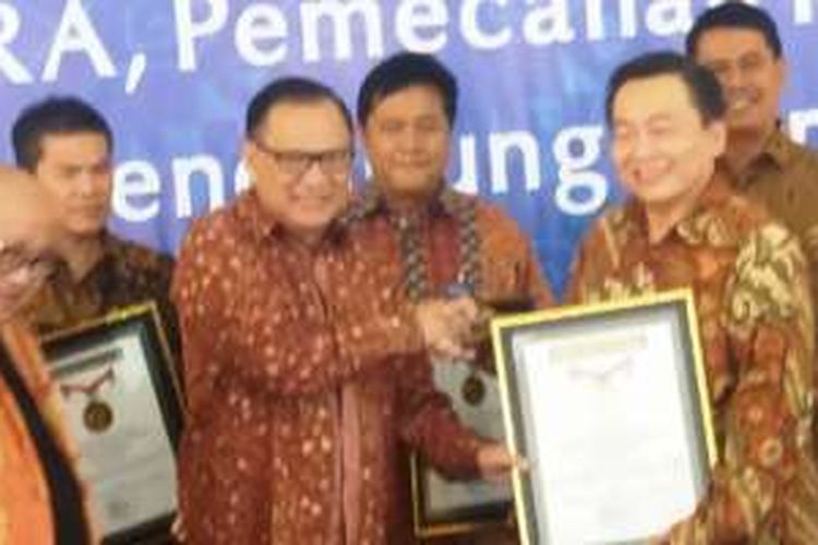Gubernur Bank Indonesia Agus D.W. Martowardojo (tengah) menyerahkan piagam penghargaan Rekor MURI kepada Direktur BCA Santoso (kanan) disaksikan Ketua Umum MURI Jaya Suprana (kiri) di Batam, Sabtu (13/8/2016).