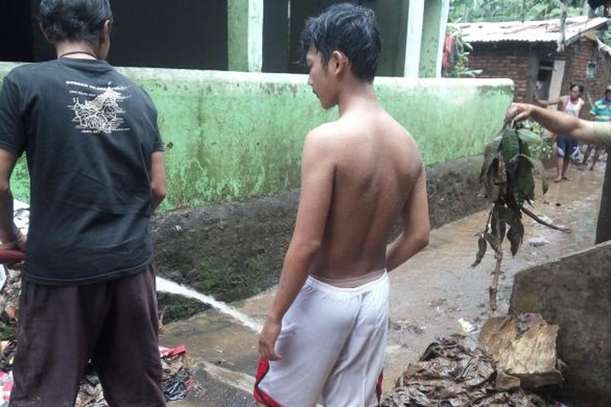 Warga Jalan Masjid Al Makmur sedang membersihkan lumpur dan sampah akibat banjir di kawasan tersebut pada Kamis (16/2/2017).