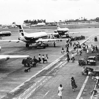 Penumpang dan pesawat udara di lapangan udara Kemayoran.