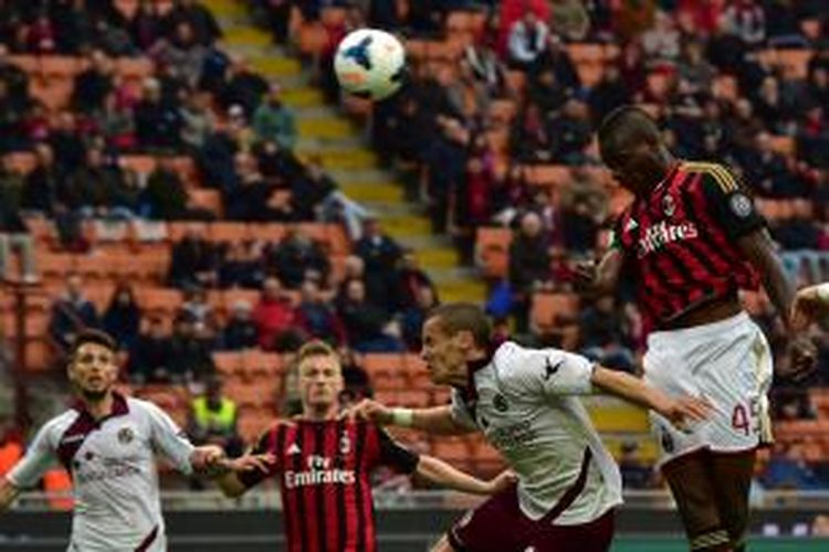 Penyerang AC Milan Mario Balotelli (kanan) menyundul bola masuk gawang Livorno, pada laga Serie-A, di San Siro, Sabtu (19/4/2014).
