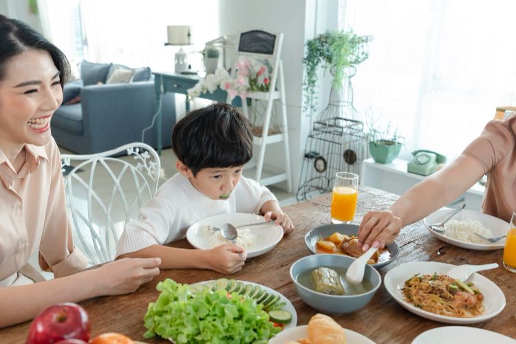 Ilustrasi anak makan bersama orangtua.