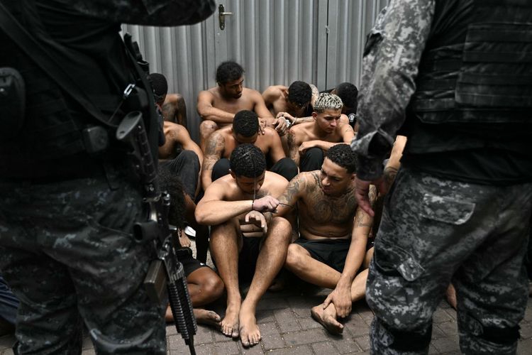 Petugas polisi mengawal para terduga penjahat yang ditangkap dalam Operasi penggerebekan narkoba di favela Vila Cruzeiro, di kompleks Penha, Rio de Janeiro, Brasil, pada 28 Oktober 2025.