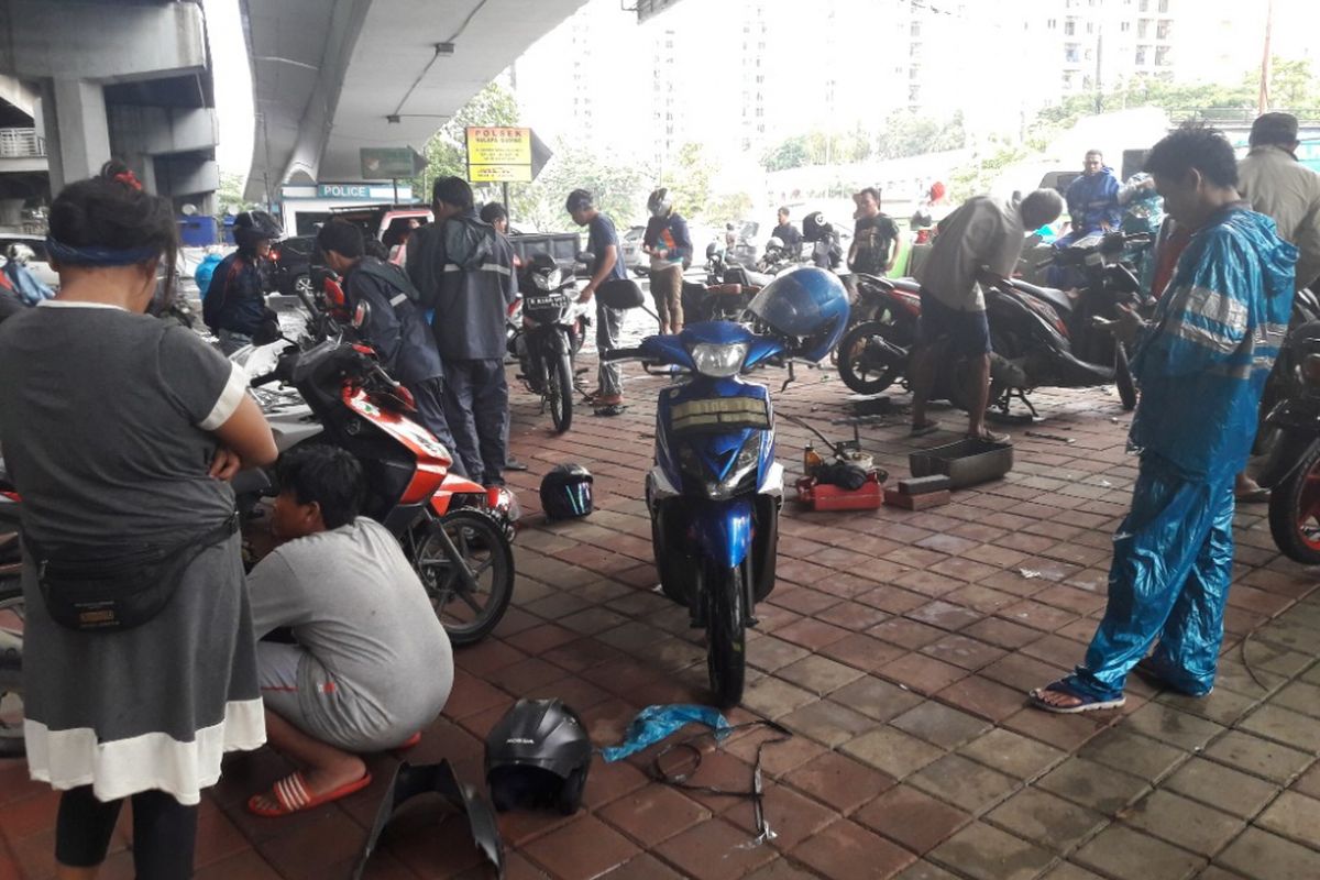Sejumlah montir dadakan tengah memperbaiki motor-motor yang mogok akibat banjir di Jalan Boulevard Barat Raya, Kelapa Gading, Jakarta Utara, Kamis (15/2/2018)