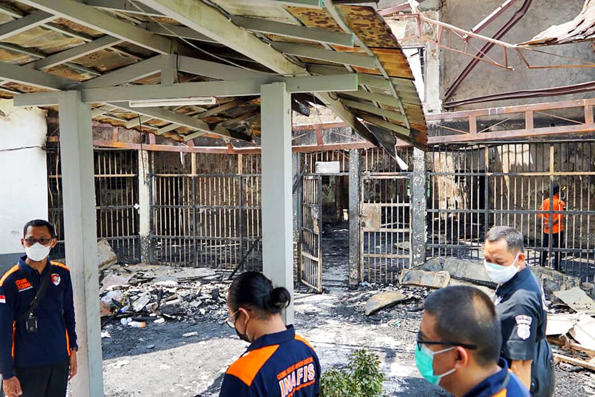 Dalam foto yang dirilis oleh Kementerian Hukum dan Hak Asasi Manusia Republik Indonesia ini, petugas polisi memeriksa sel-sel yang rusak setelah kebakaran di Penjara Tangerang di Tangerang, Indonesia, Rabu, 8 September 2021.