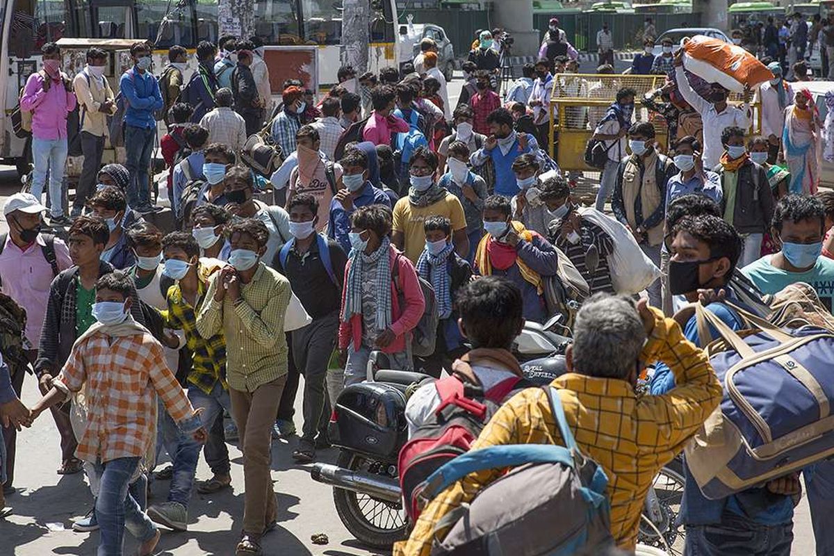 Buruh migran menunggu bus di sebuah terminal angkutan umum selama karantina wilayah (lockdown) di New Delhi, India, Minggu (29/3/2020). Pemerintah India pada 24 Maret lalu mulai memberlakukan lockdown selama 21 hari di seluruh wilayah negara itu dalam upaya mengendalikan penyebaran COVID-19.