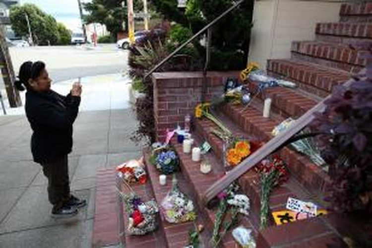 Seorang fan mengabadikan aneka rupa ungkapan duka dari para fans Robin Williams di depan rumah aktor tersebut di California, Selasa (12/8/2014). Williams (63) ditemukan tewas di rumahnya, Senin (11/8/2014), diduga karena bunuh diri. 
