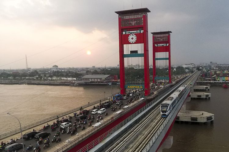 Rangkaian LRT yang dihias dengan gambar bernuansa Asian Games melintas di atas Sungai Musi, Palembang, Sumatera Selatan, Senin (23/7/2018). Bersama DKI Jakarta, Palembang sebagai kota yang dipilih menjadi tuan rumah Asian Games 2018 ikut bersolek menyambut ajang olahraga terakbar Asia yang akan berlangsung 18 Agustus hingga 2 September 2018 tersebut.