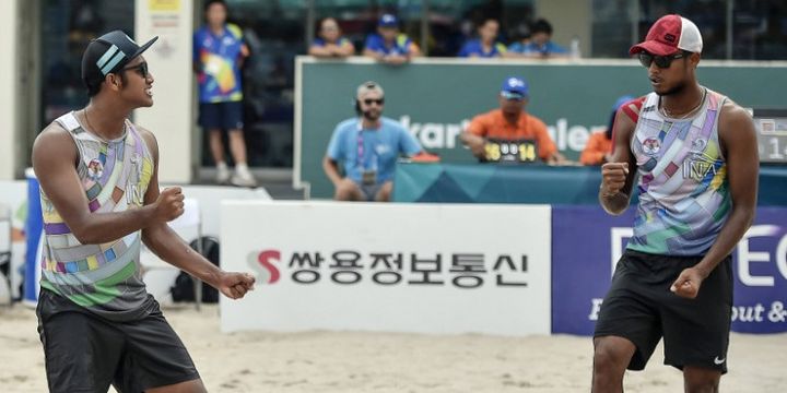 Pebola voli pantai putra Indonesia Mohammad Ashfiya (kiri)/Ade Candra Rachmawan (kanan) melakukan selebrasi seusai berhasil mengembalikan bola ke arah pevoli Cina pada pertandingan babak perempatfinal voli pantai putra Asian Games 2018 di arena Jakabaring Sport City, Palembang, Sumsel, Sabtu (25/8/2018),