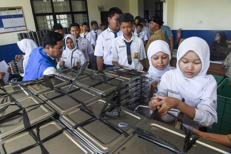 Sejumlah siswa mengantre untuk mengambil paket makanan program Makan Bergizi Gratis (MBG) saat dibagikan di SMP Negeri 13 Depok, Jawa Barat, Senin (6/10/2025). SPPG Cinere melibatkan puskesmas dan usaha kesehatan sekolah (UKS) untuk memantau secara berkala Satuan Pelayanan Pemenuhan Gizi (SPPG) atau dapur MBG guna memastikan pemenuhan gizi serta antisipasi kasus keracunan. ANTARA FOTO/Galih Pradipta/YU