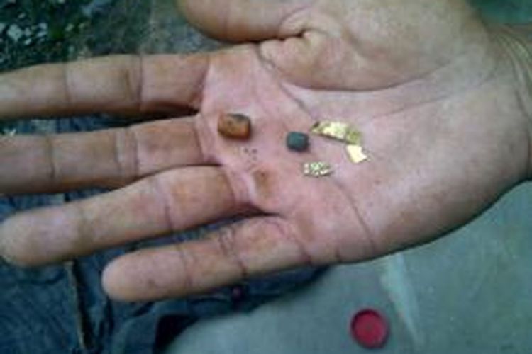 Warga menunjukkan serpihan emas dan manik yang ditemukan saat menggali tanah milik Tohir di Desa Patemon, Krejengan, Kabupaten Probolinggo, Rabu (5/2/2014).