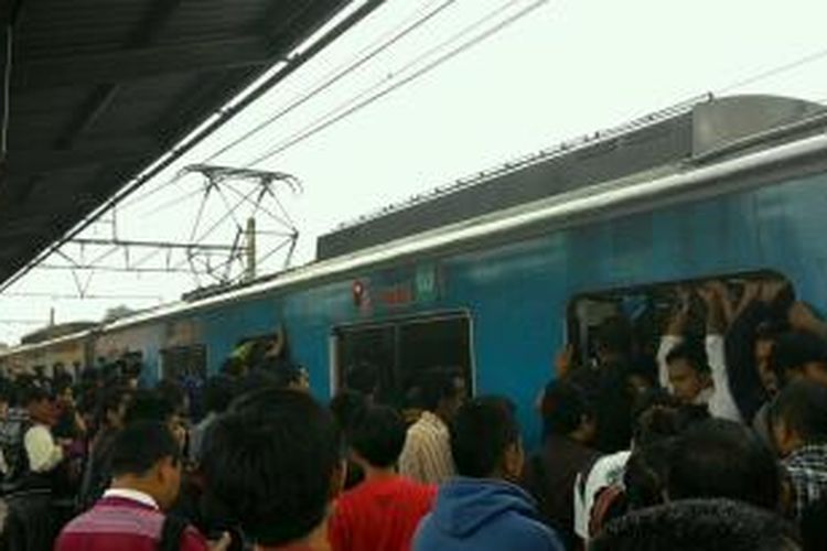 Penumpang KRL di Stasiun Depok berebutan masuk. Mereka sudah menanti KRL jurusan Jakarta yang terganggu karena KA 411 mogok di antara Stasiun Citayam dan Stasiun Depok, Senin (3/2/2014).
