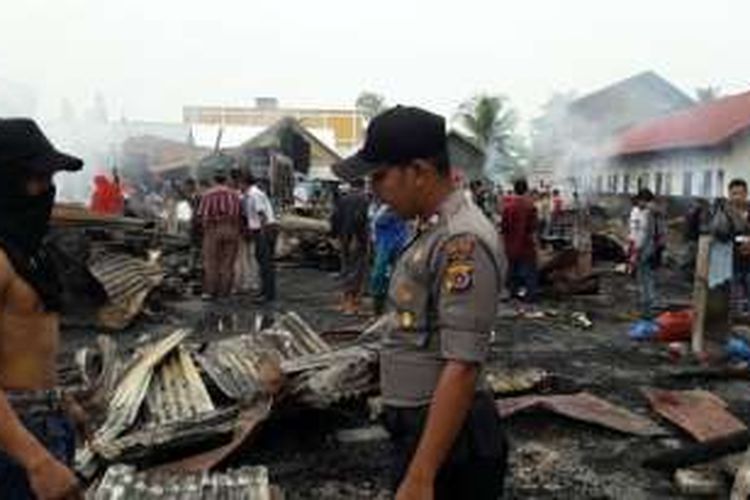 Polisi berjaga-jaga di lokasi kebakaran, Pasar Lhoksukon, Aceh Utara, Sabtu (29/10/2016)