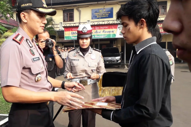 Pemuda yang menewaskan pembegal, Mohamad Irfan Bahri dan Ahmad Rafiki, mendapat piagam penghargaan dari Kapolres Metro Bekasi Kota Kombes Indarto di Lapangan Mapolres Metro Bekasi Kota, Kamis (31/5/2018).