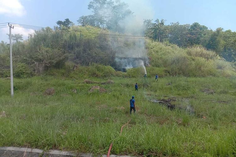 Personel Damkar Sumedang memadamkan api di lahan yang dibakar ilegal di dekat Tol Cisumdawu, Sumedang, Jabar, Senin (15/5/2023). Dok. Damkar Sumedang/KOMPAS.com