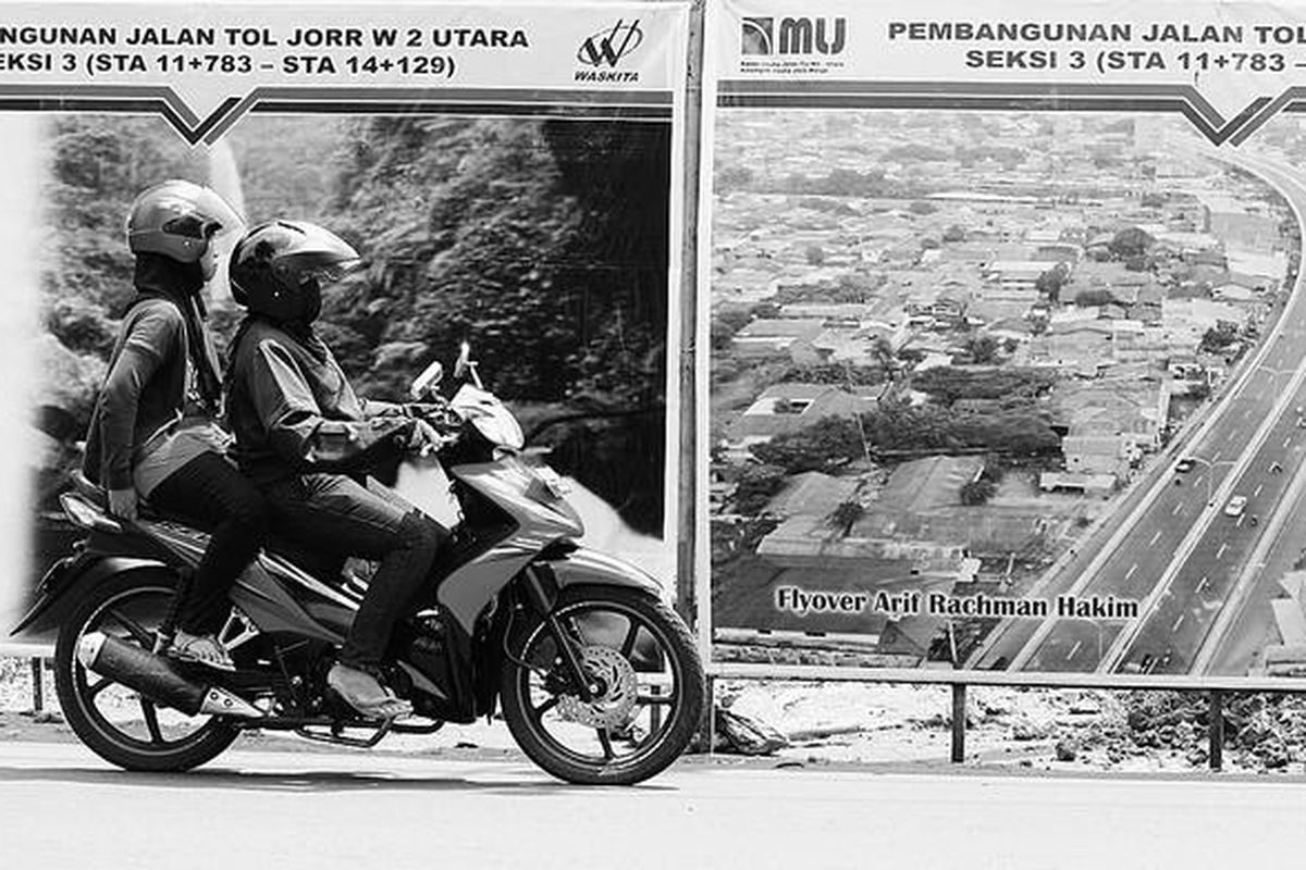 Pengendara sepeda motor melintas di depan pagar proyek  jalan tol Jakarta Outer Ring Road West 2 (JORR W2) Utara di Jalan Ciledug Raya, Kelurahan Petukangan Utara, Jakarta Selatan, Senin (26/3). Proyek JORR W2 akan tersambung dengan ruas JORR W1 yang  menghubungkan Tol TB Simatupang dengan Tol Sedyatmo.