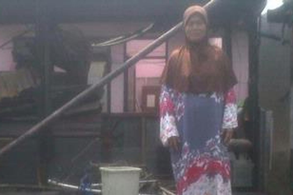 Salah satu pengungsi korban kebakaran di Karet Tengsin, Kemiyem (62), di atap rumahnya yang habis terbakar, Selasa, (7/8/2012). 