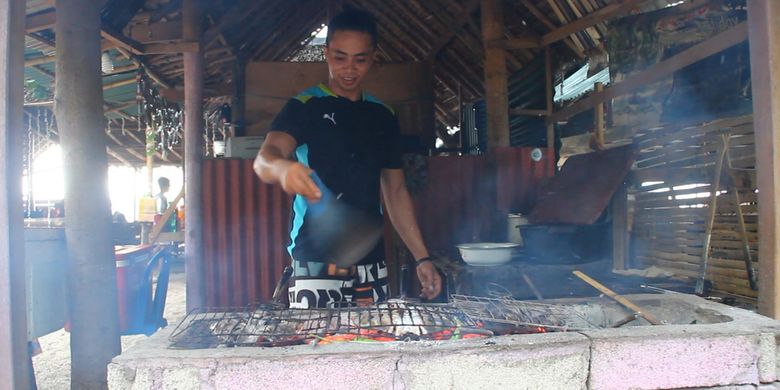 Irwan, seorang peracik ikan laut bakar di Pantai Pandanan, Kabupaten Lombok Utara, NTB, Minggu (24/12/2017).