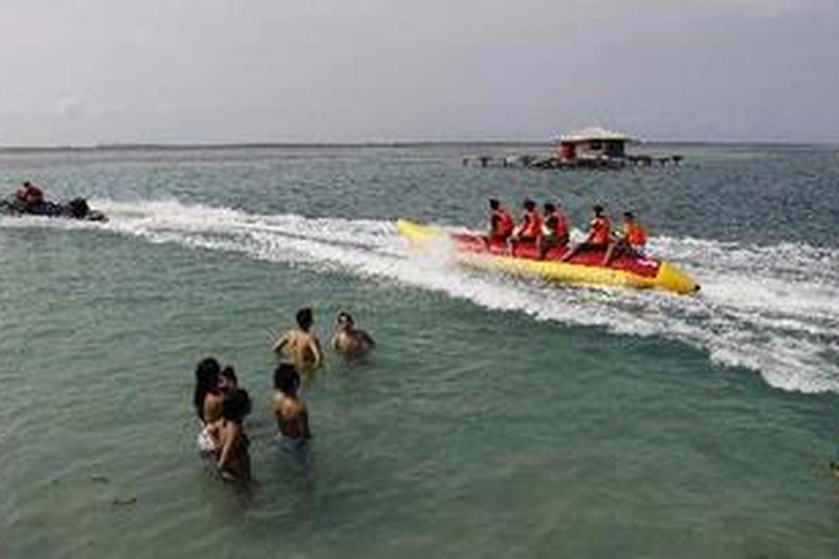 Wisatawan mandi dan bermain di jembatan yang menghubungkan Pulau Tidung Besar dan Pulau Tidung Kecil, di Kepulauan Seribu, Sabtu (14/5/2011). Pulau ini kian dikenal sebagai salah satu destinasi wisata bahari. Pada hari libur, pulau yang memiliki lebar sekitar 200 meter dan panjang hanya 5 kilometer, ini ramai dikunjungi wisatawan. 