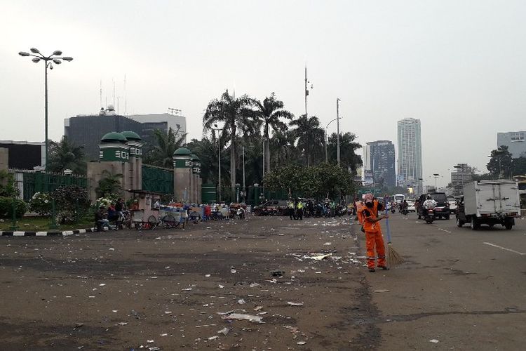 Petugas PPSU membersihkan sampah bekas aksi demo di depan gedunh DPR RI, Jalan Gatot Subroto, Jakarta Pusat pada Senin (23/4/2018).