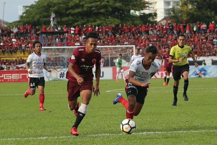 Pemain PSM Makassar (kiri) berebut bola dengan pemain Bali United dalam pertandingan Liga 1 2018 di Stadion Andi Mattalatta, Makassar, Minggu (25/11/2018).