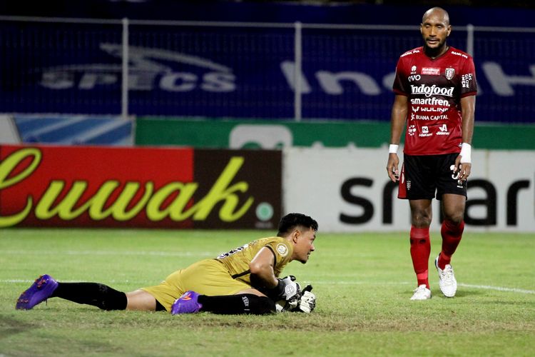 Pemain Bali United, Leonard Tupamahu (kanan) dan penjaga gawang Wawan Hendrawan (tersungkur).