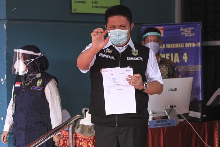Gubernur Sumatera Selatan Herman Deru menujukan sertifikat usai divaksin Covid-19 di Puskesmas Gandus, Kecamatan Gandus Palembang, Kamis (14/1/2021).