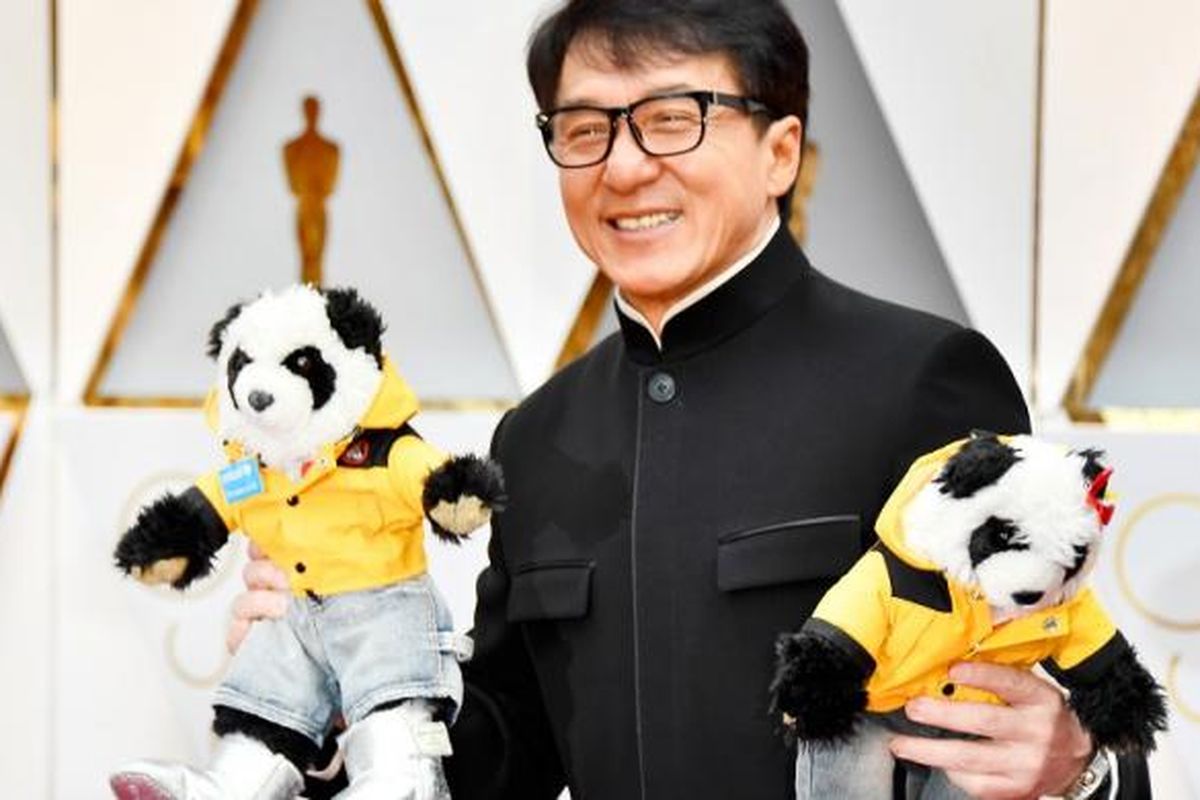 Aktor Jackie Chan membawa dua boneka panda ketika berjalan di karpet merah Academy Awards ke-89 di Hollywood & Highland Center, Hollywood California, Minggu (26/2/2017).