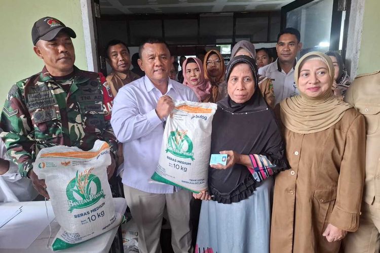 Kepala Perum Bulog Maluku Mara Karmin Siregar didampingi Kepala Dinas Ketahanan Pangan Provinsi Maluku Faradila Attamimi saat menyalurkan beras bantuan pangan 2025 kepada salah seorang warga penerima di kantor Perum Bulog Maluku, Senin (14/7/2025)