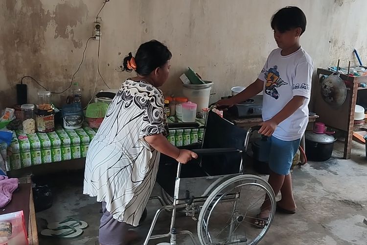 Adit saat menemani Sarmini, ibunya, yang tengah sakit stroke di rumahnya di Dusun. Kuningan Desa Tiru Kidul, Kecamatan Gurah, Kabupaten Kediri, Jawa, Timur, Selasa (14/5/2024).