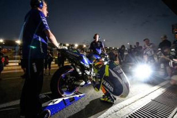 Pebalap Movistar Yamaha asal Italia, Valentino Rossi, bersiap saat akan menjalani sesi latihan bebas ketiga GP Qatar di Sirkuit Losail, Jumat (27/3/2015).