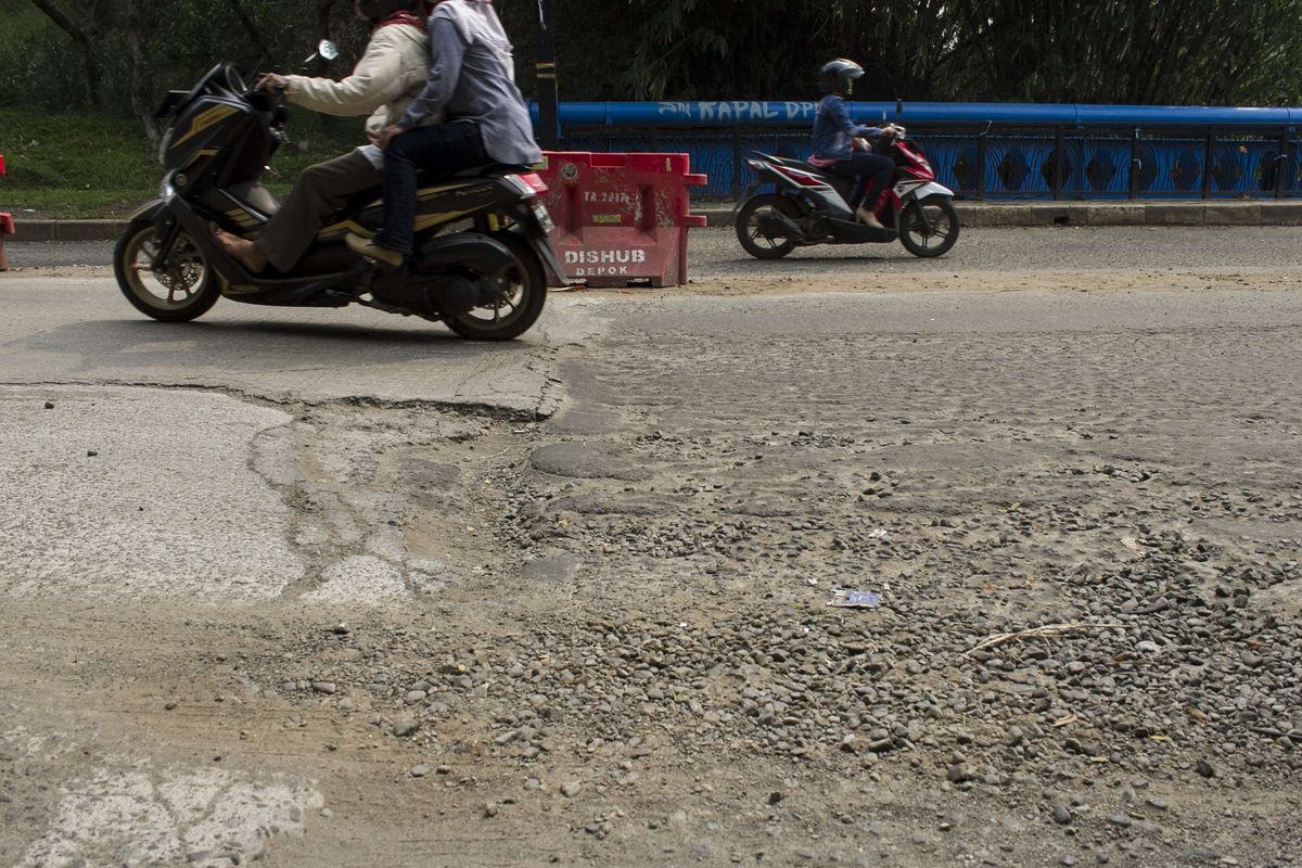 Pengendara melintasi jalan berlubang di Grand Depok City (GDC) Grand Depok City, Depok, Jawa Barat, Rabu, (11/12/2019). Beberapa jalan sepanjang GDC masih berlubang dan bergelombang.