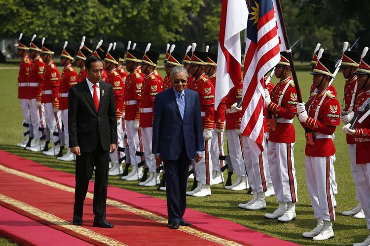 Presiden Joko Widodo (kiri) berjalan bersama Perdana Menteri Malaysia Mahathir Mohammad saat upacara penyambutan dalam kunjungan kenegaraan Mahathir di Istana Presiden Bogor, Jumat (29/6/2018). Kunjungan PM Mahathir ke Indonesia yang bertajuk kunjungan perkenalan ini diisi dengan pembahasan mengenai penguatan hubungan kedua negara, baik dari sisi ekonomi, sosial, hingga kebudayaan.