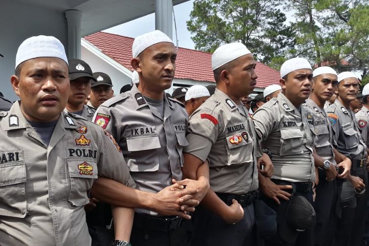 Para personel kepolisian dari Polres Aceh Tengah tampak berpeci saat menghadapi massa aksi menolak sejumlah RUU di Gedung DPRK Aceh Tengah, Senin (30/9/2019). Mereka juga berselawat untuk mencegah kerusuhan atau bentrok yang terjadi saat aksi berlangsung.