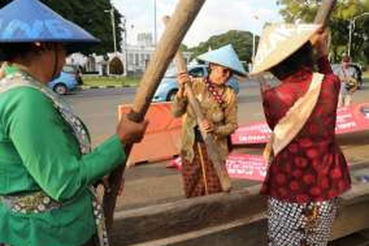 Sembilan perempuan dari Jaringan Masyarakat Peduli Pegunungan Kendeng membunyikan lesung saat berunjukrasa di depan Istana Negara, Jakarta, Senin (6/4). Selain untuk menolak pembangunan pabrik semen, mereka juga meminta kepada Presiden Joko Widodo bersedia meluangkan waktu untuk berkomunikasi dengan mereka terkait nasib petani dan keselamatan pegunungan Kendeng dari Pati hingga Rembang, Jawa Tengah. 