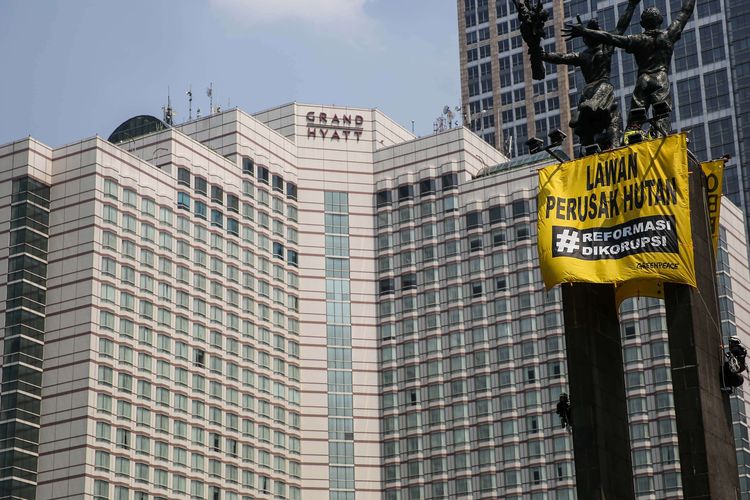 Aktivist dari greenpeace memanjat Monumen Selamat Datang atau patung Bundaran Hotel Indonesia, Jakarta Pusat, Rabu (23/10/2019). Mereka membentangkan spanduk kuning bertuliskan Orang Baik Pilih Energi Baik dan Lawan Perusakan Hutan #ReformasiDikorupsi.