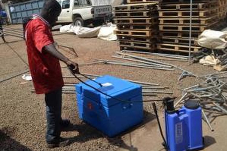 Warga menyemprotkan disinfektan untuk mensterilkan perlengkapan dari virus ebola sebelum digunakan, di sebuah kawasan di Conakry, Guniea.