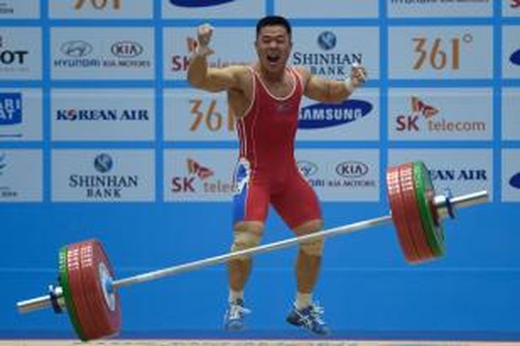 Atlet angkat besi Korea Utara, Kim Un Guk, berteriak setelah berhasil melakukan angkatan saat turun di kelas 62 kg Asian Games 2014 di Incheon, Korea Selatan, Minggu (21/9/2014).