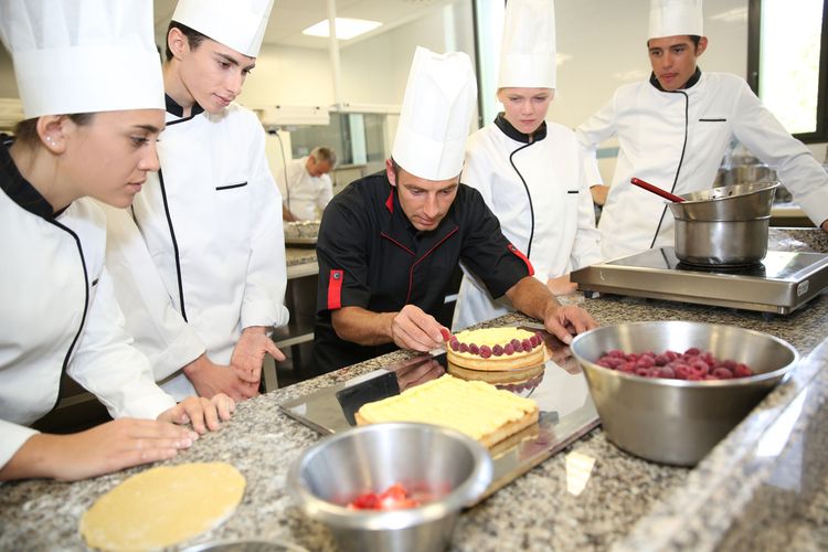 Ilustrasi chef sedang mengajarkan siswa sekolah kuliner. 