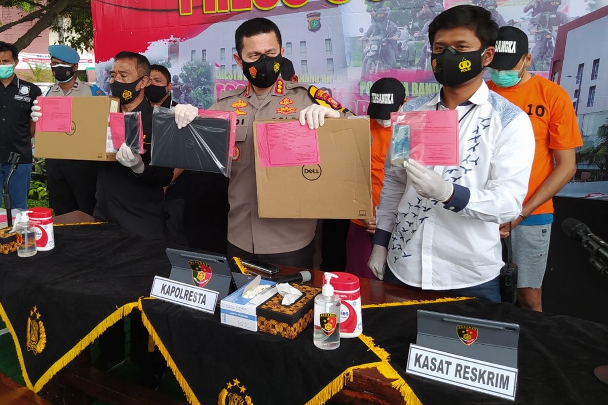 Soekarno Hatta International Airport Police Precinct head Chief Police Commissioner Adi Ferdian (middle) shows evidence of stolen laptops and other goods on Wednesday (30/12/2020)