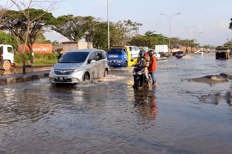Pengendara sepeda motor saat menuntut motornya yang mogok karena terendam banjir di jalan Yos Sudarso Semarang, Kamis (4/6/2020).
