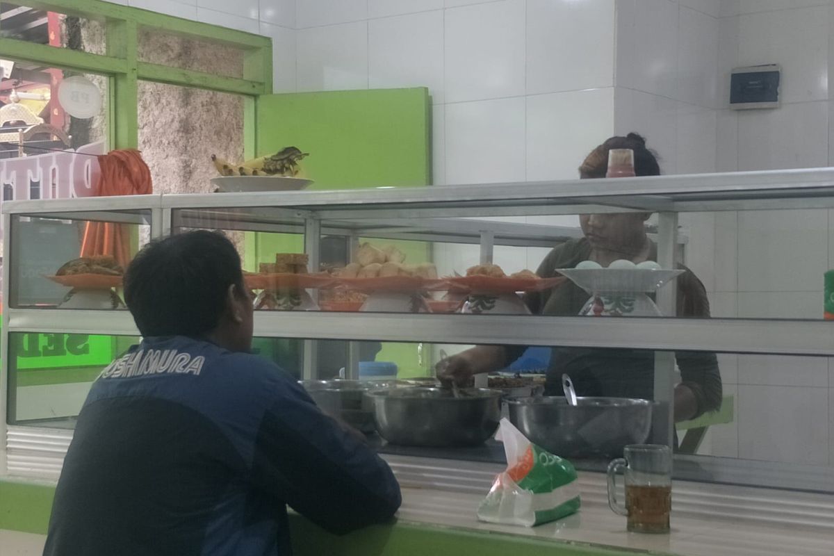 Pemilik usaha warteg di Pademangan yang mengeluh harga minyak goreng naik, sedang melayani pembeli, Kamis (28/10/2021).