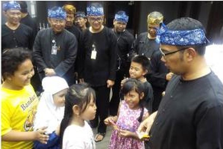 Wali Kota Bandung Ridwan Kamil saat membagikan wafer cokelat kepada anak-anak di Kelurahan Kebonlega Kecamatan Bojongloa Kidul, Kota Bandung, Rabu (12/8/2015).
