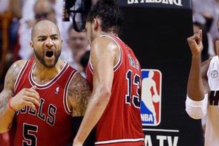 Pemain Chicago Bulls, Carlos Boozer (5), berteriak setelah pemain Miami Heat, Chris Bosh (kanan), melakukan 