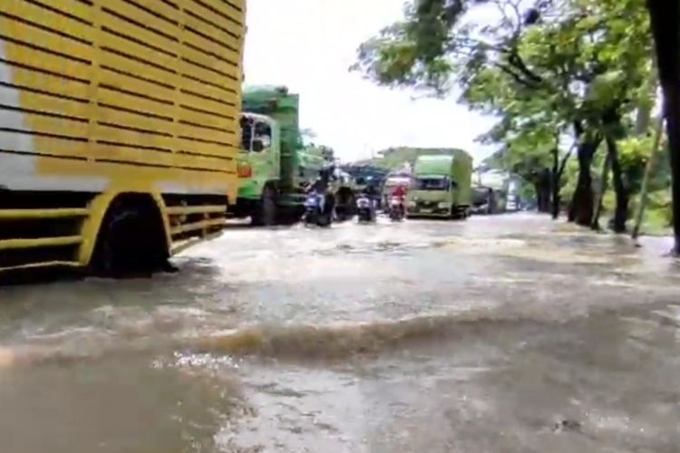 Petugas Kepolisian Sektor Klangenan, Polresta Cirebon Jawa Barat, mengatur arus lalulintas yang tersendat akibat digenangi banjir pada Rabu (6/3/2024) siang.