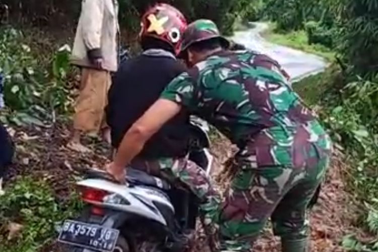 Seorang petugas membantu pengendara sepeda motor yang melewati jalan raya di Aripan, Kabupaten Solok, Sumatera Barat