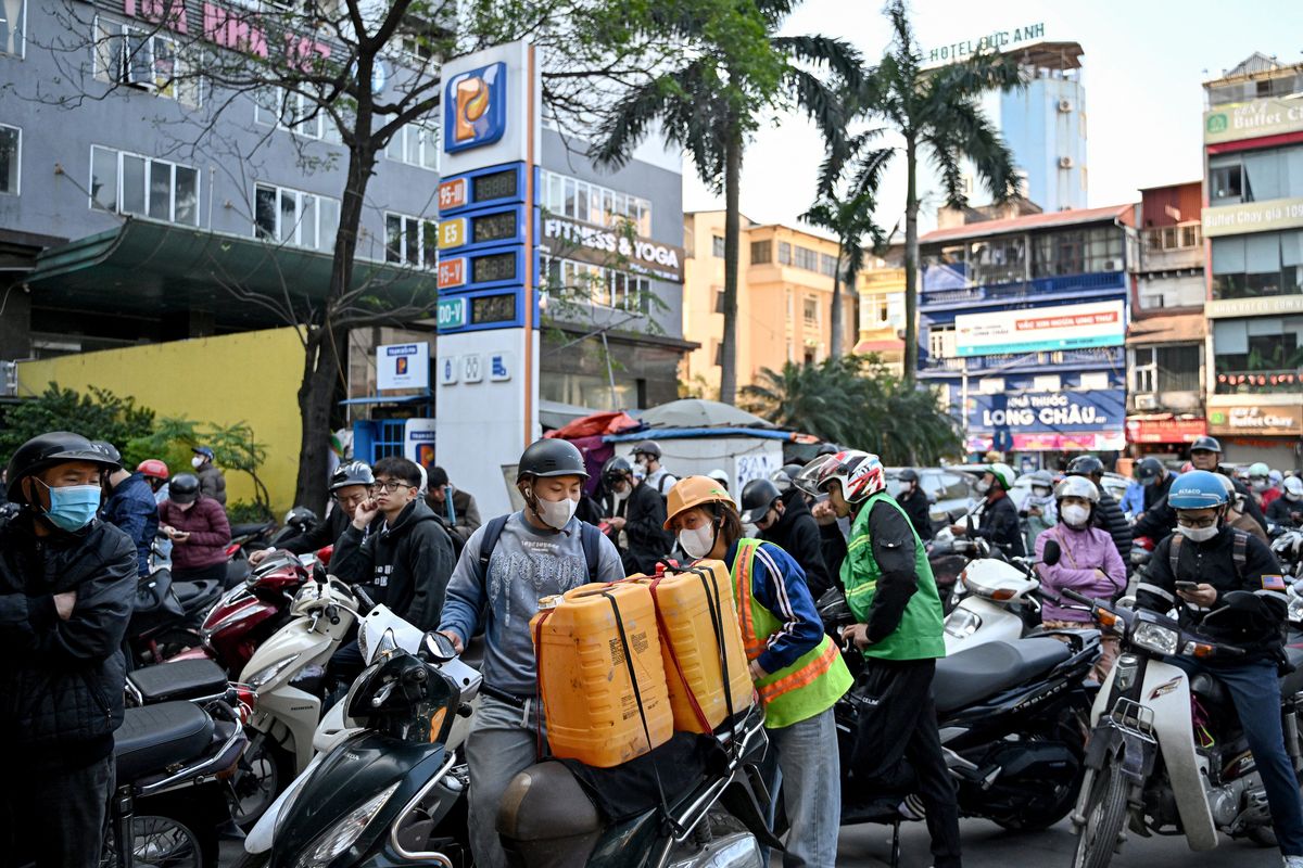 Para pengendara kendaraan bermotor mengantre untuk mengisi bensin ke kendaraan mereka dan jeriken minyak di sebuah SPBU di Hanoi pada 10 Maret 2026. Vietnam mengumumkan pada 9 Maret bahwa mereka menghapus tarif impor bahan bakar, karena perang AS-Israel dengan Iran mengganggu pasokan minyak dan mendorong harga ke level tertinggi sejak 2022.