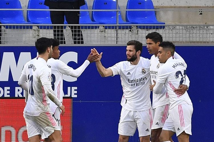 Bek Prancis Real Madrid Raphael Varane (2ndR) merayakan bersama rekan satu tim setelah mencetak gol kedua selama pertandingan sepak bola liga Spanyol antara SD Huesca dan Real Madrid di stadion El Alcoraz di Huesca pada 6 Februari 2021.