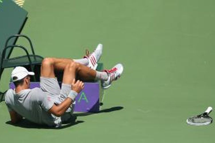Petenis Serbia Novak Djokovic terjatuh saat mencoba mengejar bola dari petenis Spanyol, Tommy Robredo, pada babak keempat Sony Open Tennis di Crandon Park Tennis Center, Miami, Selasa (25/3/2014).